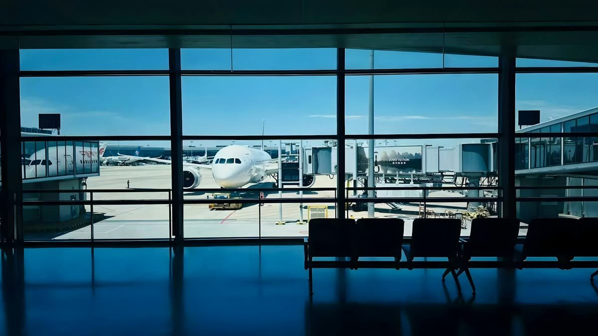 An aircraft on the apron seen through a terminal window