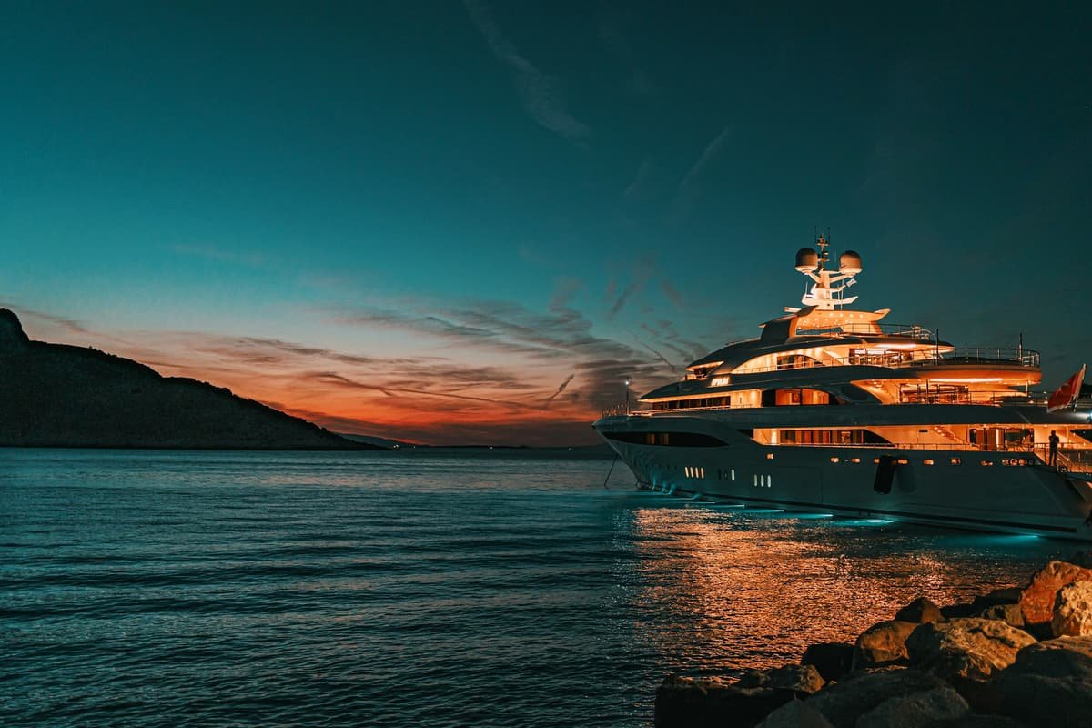 A large yacht at anchor in a bay at dusk